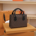 Vintage brown plaid handbag with black leather handles on an orange gift box - Black