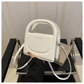 Nahaufnahme der weißen Lederhandtasche mit Rundgriff und silbernen Metallbeschlägen - Weiß