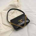 Schicke schwarze Klappentasche mit goldenem Verschluss und Kette auf weißem Sakko - Schwarz