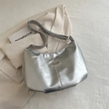 Silver metallic dumpling tote bag with adjustable strap on a neutral blazer background - Silver