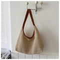 Dettaglio borsa da spiaggia in paglia con finiture in pelle marrone e texture uncinetto - Marrone