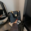 Elegante borsa nera strutturata con manico arricciato e chiusura in metallo dorato - Nero