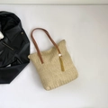 Große geflochtene Strohtasche mit braunen Lederriemen und gelbem Quastenanhänger - Khaki
