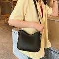 Vue détaillée d'un sac hobo noir minimaliste avec design ondulé et boucle dorée en métal - Noir