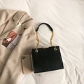 Sac à bandoulière noir motif crocodile avec chaîne dorée sur fond minimaliste - Noir