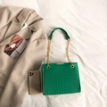 Sac bandoulière vert motif crocodile avec chaîne dorée sur fond de blazer beige - Vert