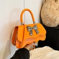 Vibrant orange handbag with a silver mirror bow detail and a circular top handle - Orange