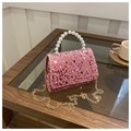 Close-up of pink sequined evening bag with white pearl handle and gold chain detail - Pink