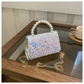 Macro detail of iridescent sequins and faux pearl handle on a luxury mini handbag - Off White