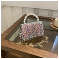 Macro shot of colorful sequined mini bag with pearl handle and gold chain detail - Gold