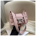 Close-up of pink pleated shoulder bag with a silver metallic bow decoration - Pink