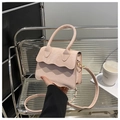 Detailed close-up of pink handbag featuring unique scalloped edges and matte texture - Pink