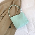 Bolso tote verde menta de nailon con letras en relieve sobre una americana beige - Verde azulado