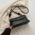 Minimalistische zwarte baguette tas met gouden gesp op een beige blazer jasje - Zwart
