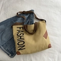 Khakifarbene Canvas-Einkaufstasche mit braunen Riemen und großem schwarzen Fashion-Druck - Khaki