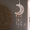 Macro shot of crescent moon suncatcher with raw crystals and heart prism reflecting rainbow - White Moon Tree Suncatcher