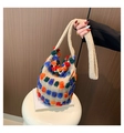Detail der kreativen Strick-Eimertasche mit bunten Bommeln und weichem Griff - Khaki