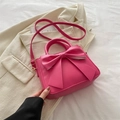 Minimalist pink bow crossbody bag with gold hardware on beige aesthetic background - Rose Pink