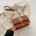 Borsa a tracolla trapuntata marrone con catena dorata e nappa su blazer bianco - Marrone