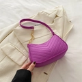 Magenta V-quilted crossbody bag with gold chain strap on stylish white blazer - Purple