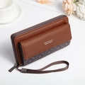 Detail of long brown textured leather wallet with wristlet and floral props on desk - Coffee