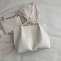 Minimalist white tote bag with vertical stitching and slim handles on fabric background - White