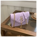 Détail du sac matelassé lilas avec couture en V, fermoir doré à pompon et chaîne - Violet