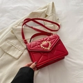 Chic red quilted crossbody bag featuring a golden heart crown buckle and strap - Red