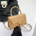 Minimalistische beige leren handtas met metalen sluiting en afneembare riem op een bureau - Khaki
