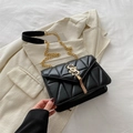 Chic black quilted square shoulder bag with gold S-logo and fringe charm detail - Black