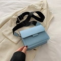 Bolso bandolera azul claro de cuero sintético con correa ancha negra sobre blazer blanco - Azul