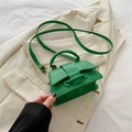 Mini borsa a mano in pelle litchi verde con manico e tracolla su lenzuola bianche - Verde