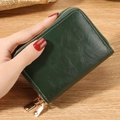 Dark green RFID leather card holder with dual gold zippers in a hand-held display - Green