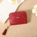 Dettaglio del portafoglio rosso trapuntato con logo oro, zip con frange e decoro floreale - Rosso