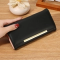 Long black leather wallet for women featuring a gold metal bar and pink lining - Black