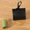 Black leather dog poop bag dispenser with metal ring on light wood background - Black