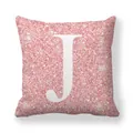 Détail d'une housse de coussin rose pailleté avec une lettre J majuscule blanche au centre - 45x45 cm / Lettre J