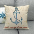 Beige nautical cushion cover featuring a blue anchor design on a soft grey sofa - Vintage Anchor Style