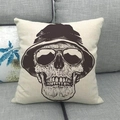 Fodera per cuscino in lino con teschio, cappello e occhiali su un divano grigio - Stile Teschio con Cappello a Secchiello e Occhiali da Sole