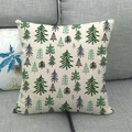 Close-up of linen pillowcase with green Christmas tree patterns on a grey sofa - Nordic Pine Tree Style (6)