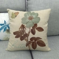 Fodera per cuscino vintage in lino con fiori e farfalla su un divano grigio - Motivo Faith (2) / Standard