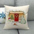 Linen Christmas cushion cover featuring Village Bakery print and snowman on grey sofa - Winter Bakery Scene (7)