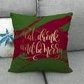 Detail of linen cushion cover with gold Eat Drink and Be Merry text on a grey sofa - Eat Drink and Be Merry Style