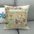 Linnen kussenhoes met vintage bloemenwinkelprint op een grijze bank - Cadeauwinkel Illustratie (1)