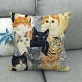 Detailaufnahme bunter Katzen-Illustrationen auf Leinen-Kissenbezug auf grauem Sofa - Realistische Katzenporträts Sammlung