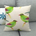 Federa in lino con uccelli verdi sui rami, presentata su un divano grigio - 45x45cm / Motivo Uccello Verde su Ramo (2)