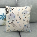 Detalle de funda de cojín de lino con notas musicales negras y letras azules en beige - Notas Musicales y Letras (2)