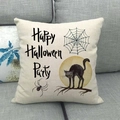 Linnen Halloween kussensloop met Happy Halloween Party tekst op een grijze stoffen bank - Halloween Feest Zwarte Kat Stijl