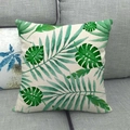Detalle de funda de cojín de lino con estampados de hojas tropicales sobre un sofá gris - 45x45 cm / Estilo de Hoja de Palma Botánica Tropical (3) / Verde
