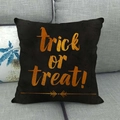 Detail of linen Halloween cushion with Trick or Treat slogan on a gray sofa - Orange Gold Slogan Black Style (1)